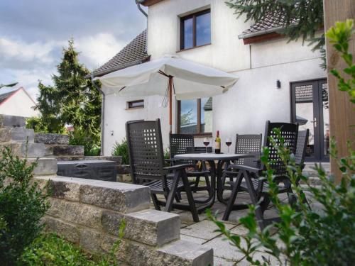 a patio with a table and chairs and an umbrella at Apartment mit Terrasse by Interhome in Mönkebude