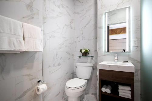 a white bathroom with a toilet and a sink at Starmax City's Hotel YALOVA in Kâzımiye