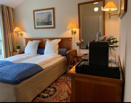 a bedroom with a bed and a desk with a laptop at Starmax City's Hotel YALOVA in Kâzımiye