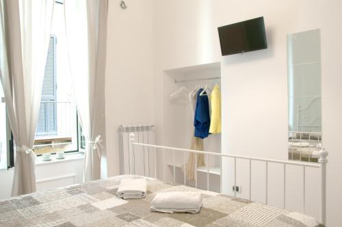 a white bedroom with a bed and a window at Sfumature Partenopee in Naples