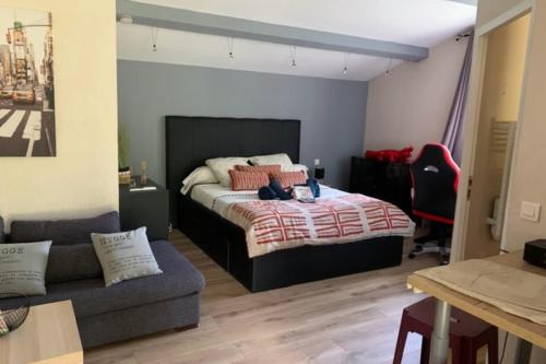 a bedroom with a bed and a couch at Gite Studio indépendant au cœur du Luberon in Maubec