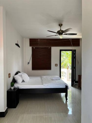 una camera con letto e ventilatore a soffitto di Amara Angkor Boutique a Phumĭ Réach Born