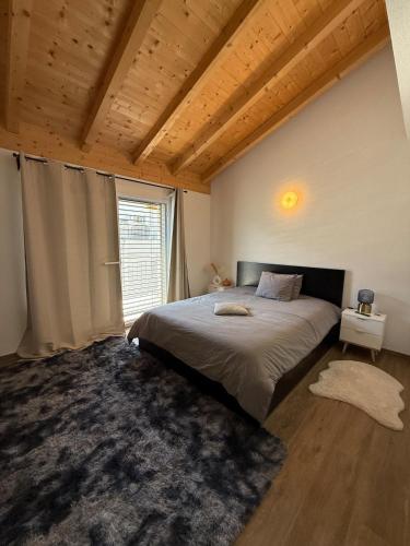 a bedroom with a large bed and a large window at Appartement Vue Montagne Vignoble Cosy Valais in Chamoson