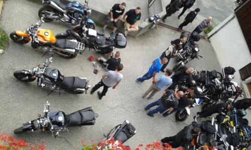 a group of people standing around a group of motorcycles at Hôtel Flor'Alpes in La Giettaz