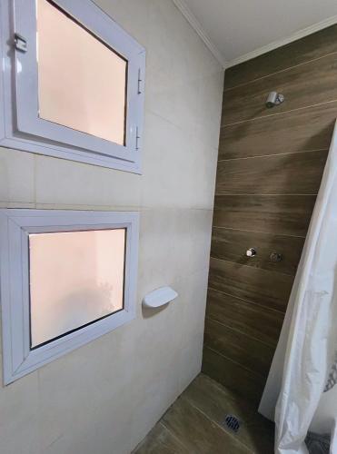 a bathroom with two windows on the wall at Complejo belgrano in General Roca