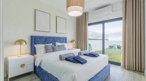 a bedroom with two beds and a large window at Luna do Mar - Luxury apt with Jacuzzi in Gaula