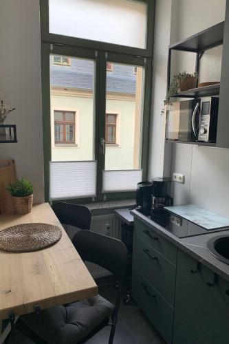 a kitchen with a table and a table and two windows at Apartment Stadtwohnung by Interhome in Plauen