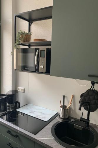 a kitchen counter with a sink and a microwave at Apartment Stadtwohnung by Interhome in Plauen