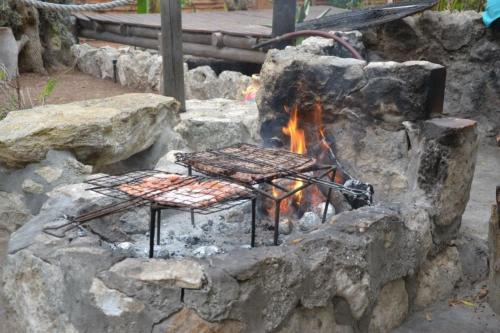 a stone fire pit with two benches in it at The Plot West Coast Style Glamping & Accommodation in Jacobs Bay
