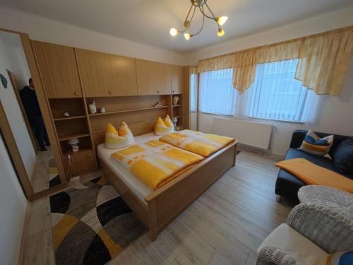 a bedroom with a bed with yellow sheets and a couch at Apartment Siegmund by Interhome in Waltershausen