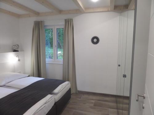 Schlafzimmer mit einem Bett und einem Fenster in der Unterkunft Ferienhaus Marianne in St. Wolfgang