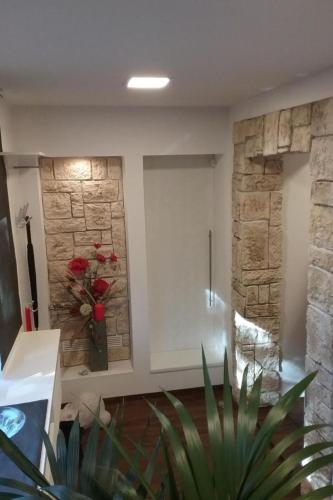 a bathroom with a tub and a stone wall at Apartment Bergnest by Interhome in Bad Gottleuba