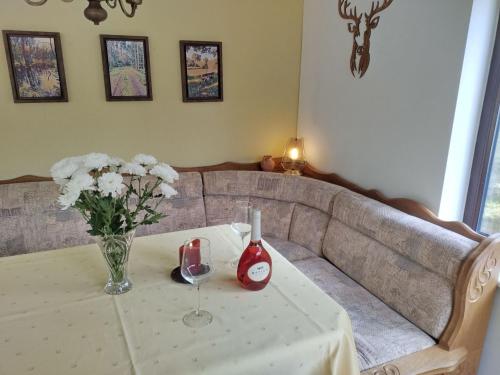a table with a vase of flowers and a couch at Holiday Home Itzinger by Interhome in Ziesar