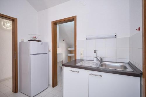 a kitchen with a sink and a white refrigerator at Bella Vista Dalmatien in Čelina