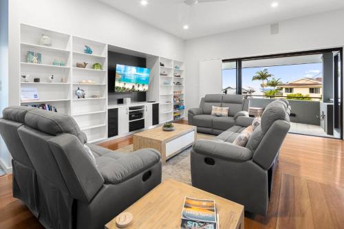 a living room with two couches and a tv at Coffs Jetty Beach House in Coffs Harbour