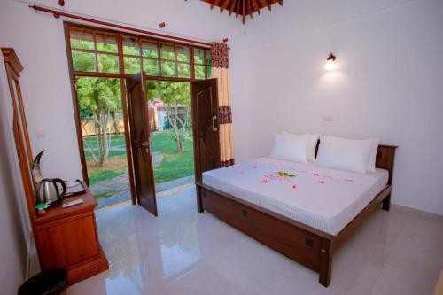a bedroom with a bed and a large window at Villa Silent Harbour in Bentota