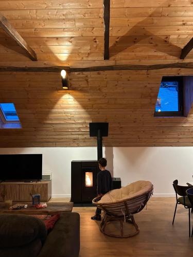 a boy sitting in a living room with a fireplace at La grange Ausar in Bareilles
