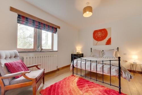 a bedroom with a bed and a chair and a window at 4 Bed in High Peak oc-dcchb in Chinley