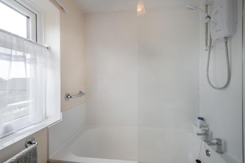 a white bathroom with a shower and a window at 2 Bed in Reedham oc-c31116 in Haddiscoe