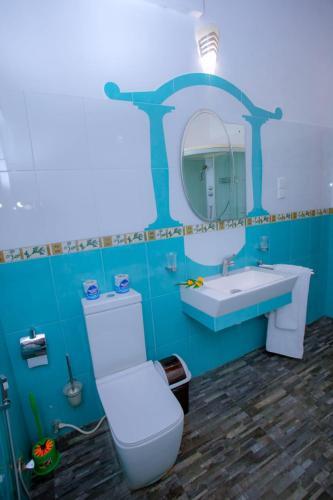 a bathroom with a toilet and a sink and a mirror at Villa Silent Harbour in Bentota