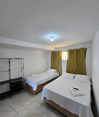 a bedroom with two beds and a window at Apartamento Cantinho do Mar in Natal