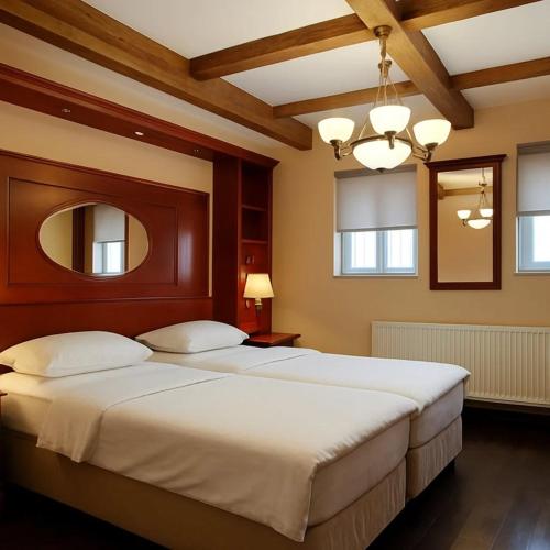 a bedroom with a large bed and a mirror at Salaš 1860 - Palić in Palić