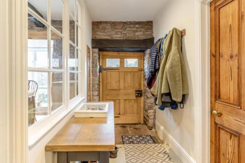 a hallway with a wooden door and a wooden table at 3 Bed in Trellech oc-j34206 in Trelleck