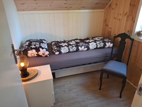 a small room with a bed and a chair at Fritidshus Hammare Hagfors in Hagfors