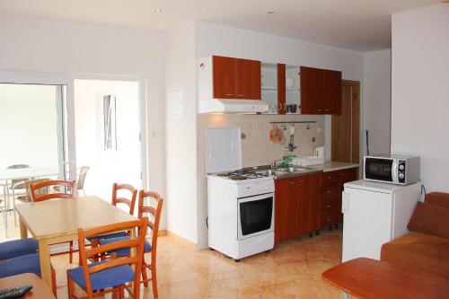 a kitchen with a white stove top oven next to a table at Vanda Seafront Superior in Cavtat