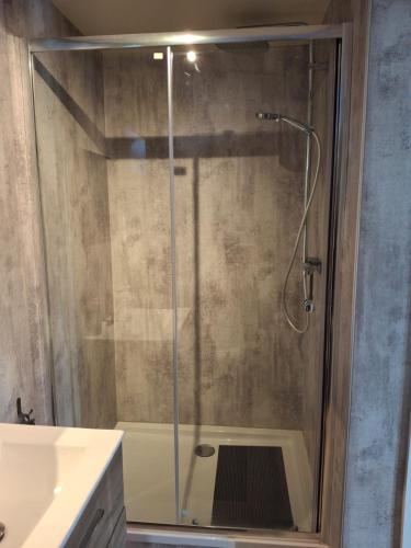 a shower with a glass door in a bathroom at Fritidshus Hammare Hagfors in Hagfors