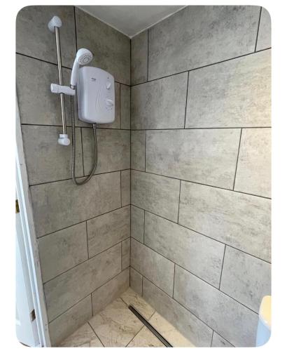 a shower with a shower head in a bathroom at Shangri-La in Chesham