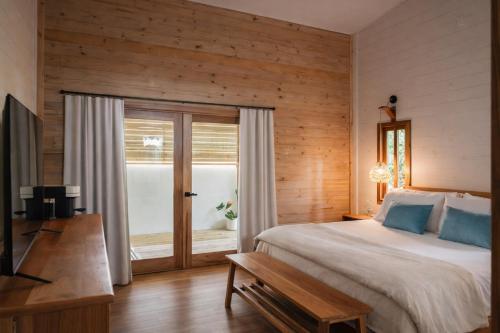 a bedroom with a bed and a sliding glass door at La Casa Selva in Bocas Town