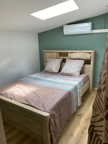 a bedroom with a bed with a wooden headboard at Maison dans le quartier de terre sainte Nicolas in Saint-Pierre