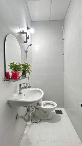 a bathroom with a sink and a toilet and a mirror at Nhà Nghỉ Như Ý in Phan Rang–Tháp Chàm