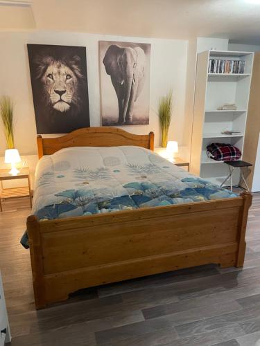 a bedroom with a wooden bed with a lion on the wall at Gîte d'Avalon Chambre 7 in Dinant