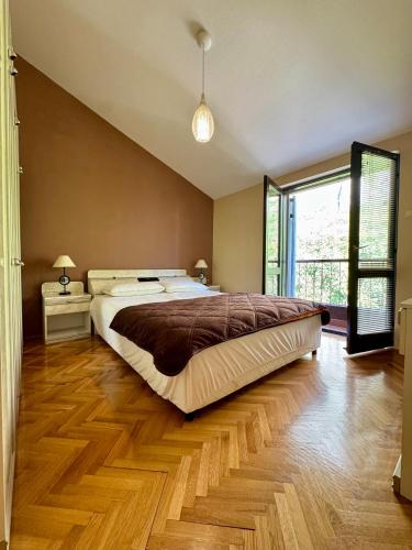a bedroom with a large bed and a wooden floor at Apartment Magdalena in Dobrota