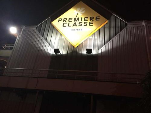 a sign on the side of a building at night at Premiere Classe St Etienne Nord Villars in Villars