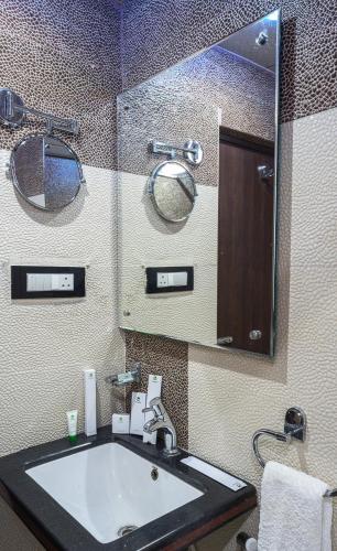 a bathroom with a sink and a large mirror at Treebo Empire in Vijayawāda