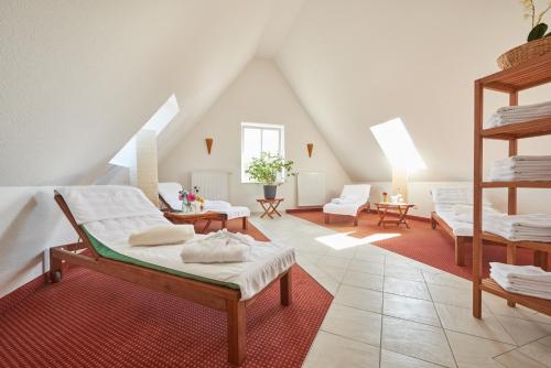 a attic room with two beds and a couch at Hotel & Restaurant Alte Schule in Siek