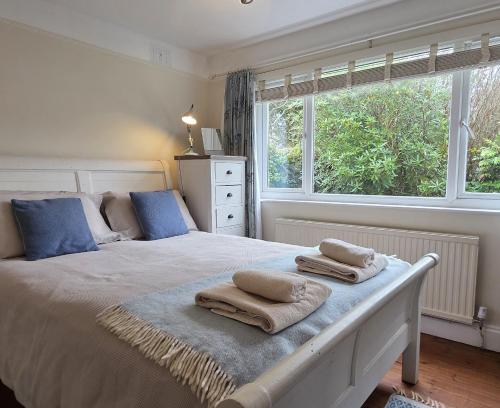 a bedroom with a bed with towels on it at Cosy room, en-suite with kitchenette in St. Davids