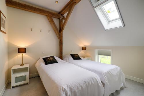 two beds in a room with a skylight at Op de Kuyerlatten in Zwolle