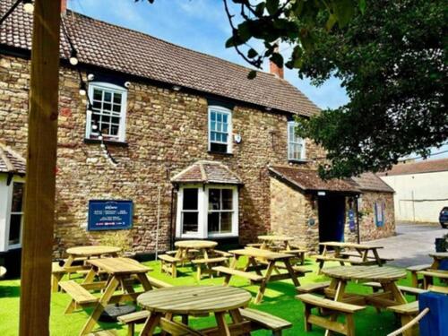 a group of picnic tables in front of a brick building at The Poacher Portishead in Portishead