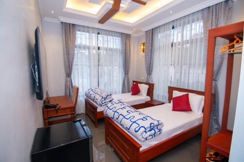a room with two beds and a television and a television at Kilimont Hotel in Mabire