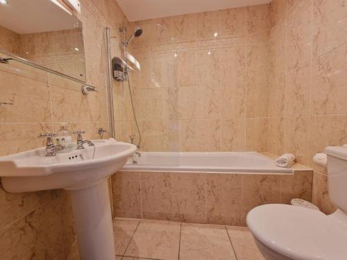 a bathroom with a sink and a tub and a toilet at Rowsley Cottage Bakewell Peak District in Bakewell