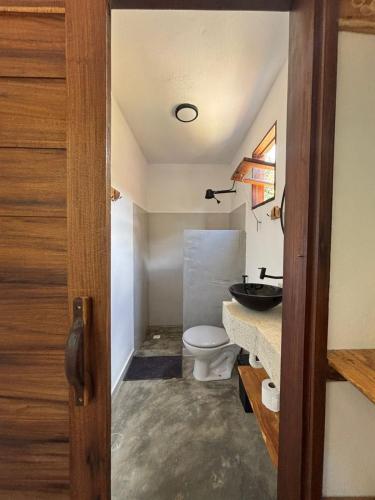 a bathroom with a toilet and a sink at CASA NANDOS Studio quintal da mata !!! in Itacaré