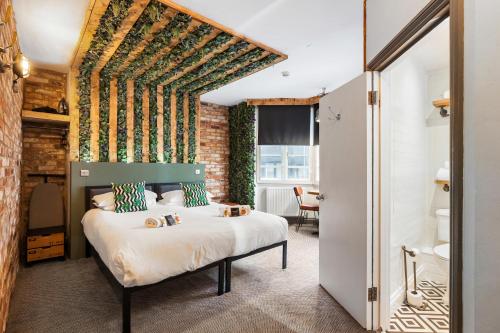 a bedroom with a bed and a brick wall at One Broad Street in Brighton & Hove