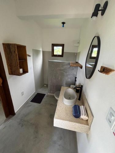 a small bathroom with a sink and a mirror at CASA NANDOS Flat Essência !!! in Itacaré