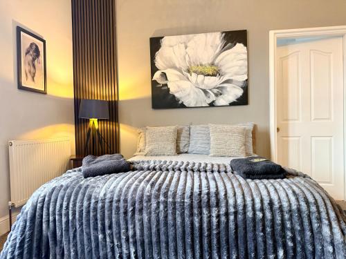 a bedroom with a bed with a blue and white blanket at St Andrews house Hotel in Preston