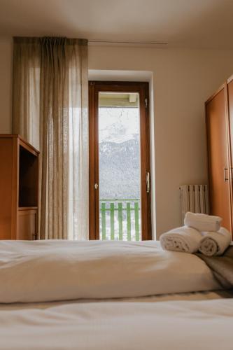 a bedroom with a bed and a window with a view at Hotel Costaverde "ai Roni" in Andalo