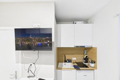 un salon avec une télévision dans une cuisine blanche dans l'établissement Bleu saphir, à Troyes